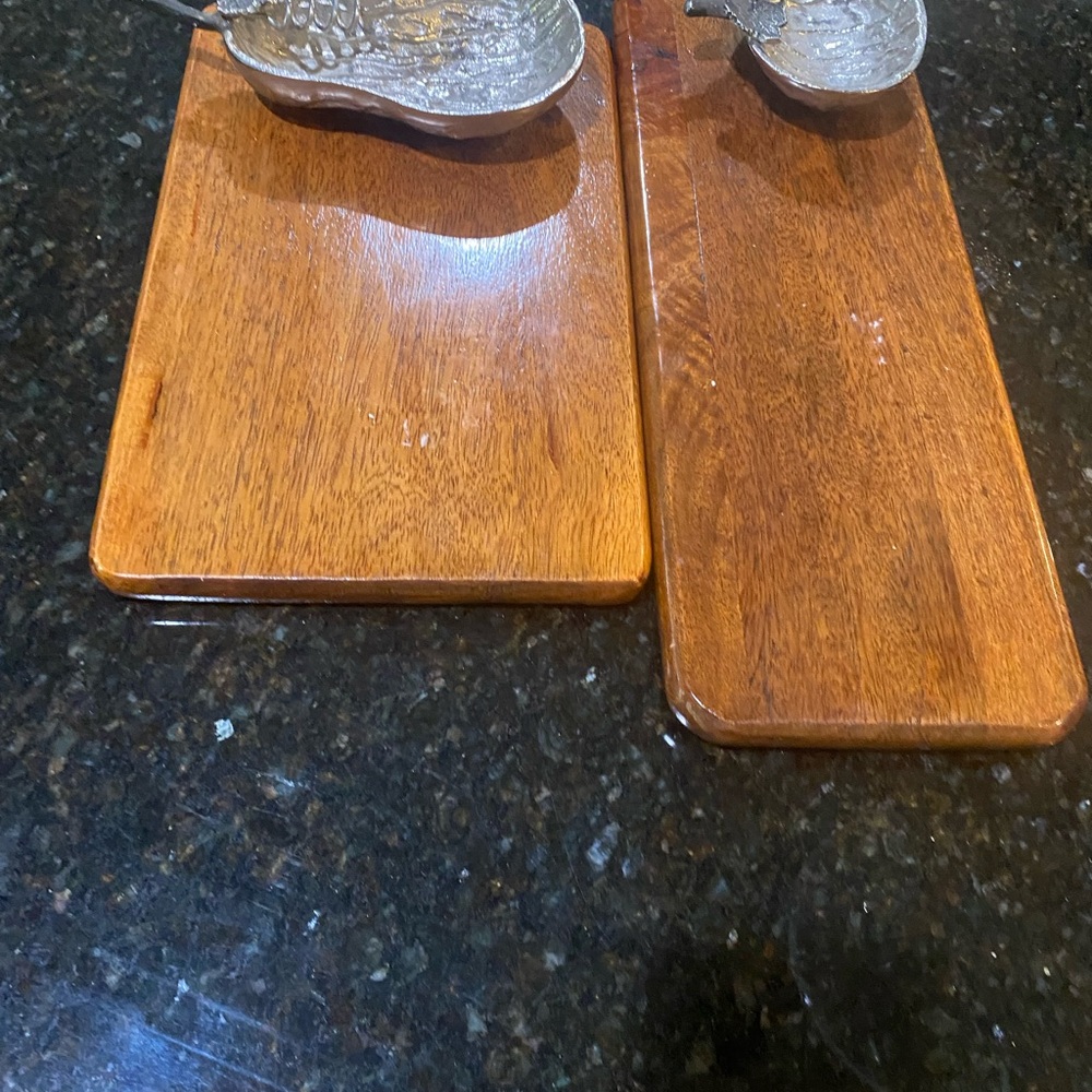 two wood cutting boards with pewter bowls
